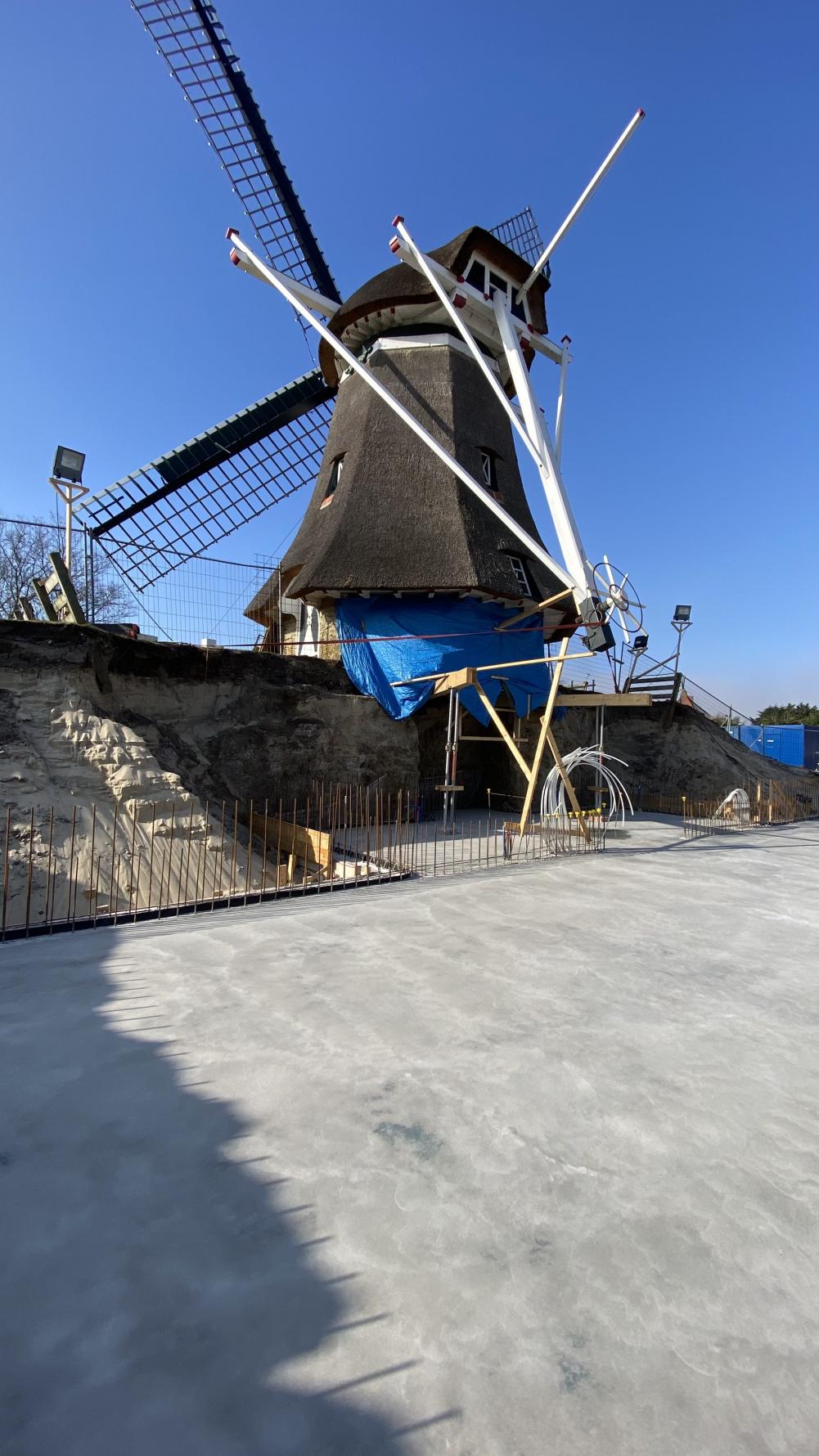 molen voor de helft ondergraven en 'zwevend' boven de bouw